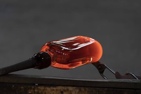 glass master while working in Murano furnace glass factory Venice Italy close up detail