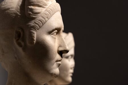 ancient roman head marble sculpture isolated on black backgroundの写真素材