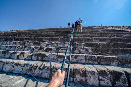 MEXICO CITY, MEXICO - JANUARY 30 2019 - Tourist climbing Teotihuacan pyramid ancient ruins one of...