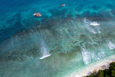 waves on reef in seychelles paradise beach aerial drone panorama landscape of la digue islandの写真素材