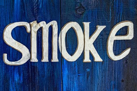 smoke hand painted sign on blue woodの写真素材