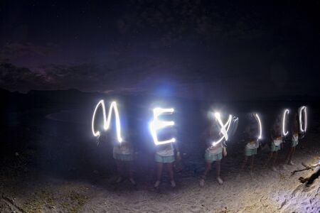 Mexico glow light painting writing on the beach at nightの写真素材
