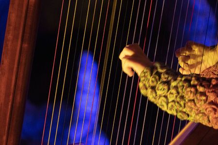 hands playing harp detail close up