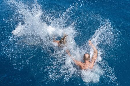 people jumping in water in maldives paradise