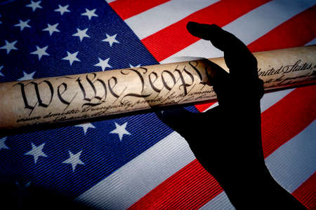 hand fingers catching american constitution we the people on american flag