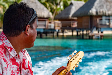 Man playing Hukulele in Bora Bora French Polynesia landscape