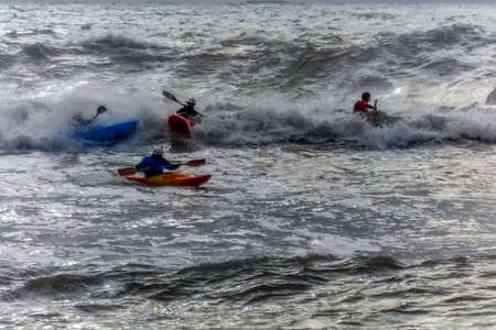 Kayaks in big waves in Genoa Nervi harbor during sea storm