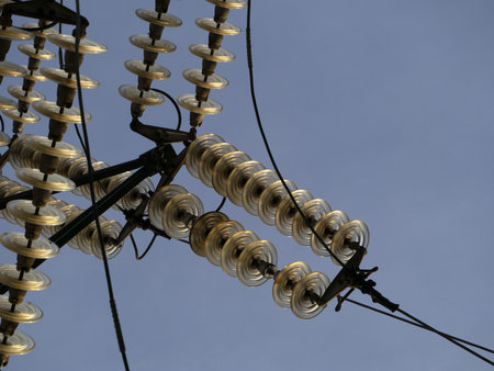 High Voltage electric wires cap and pin insulator detail on blue sky