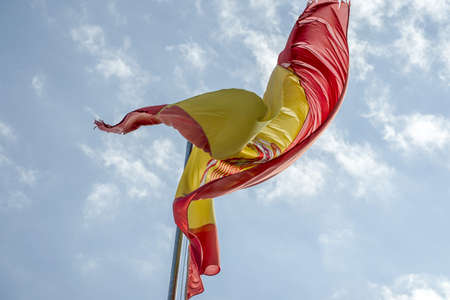 waving spain flag in the blue sky backgroundの写真素材