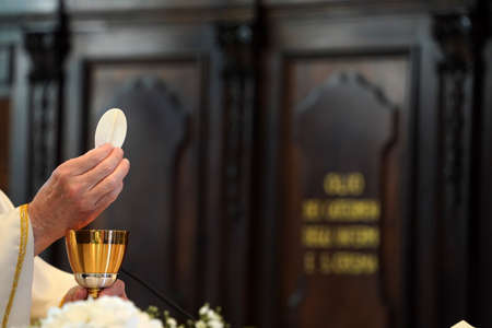 Priest showing the host during the mass detail