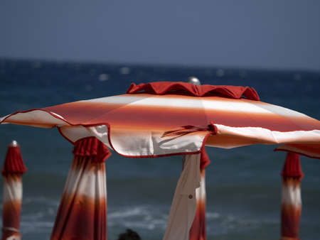 summer sun umbrellas on liguria beach riviera of flowersの写真素材