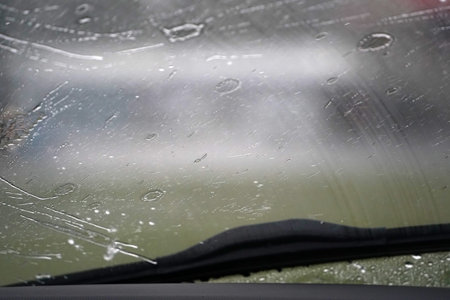 heavy rain on car windscreen wiper detailの写真素材