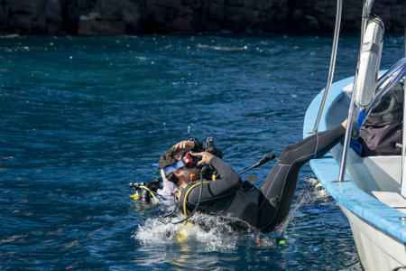 scuba diver entering water sea from boatの写真素材