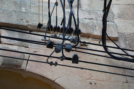 Malta electric wires hanging on building detailの写真素材