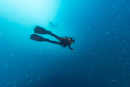 scuba diver in the deep blue ocean like star field space