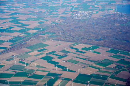 An aerial view of wind farm Multiple wind turbines generating eco friendly green energy for a better environment. fields next to a canal Waalwijk, Noord-Brabant, Netherlands.の写真素材