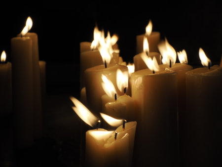 Flame of candles on a grave. All Saints day. Votive candle on a dark black background. The Day of the Dead.の写真素材