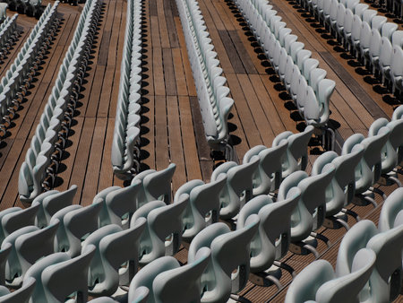 Rows of numbered empty plastic seats at an open-air amphitheater many audience open theater seatsの写真素材