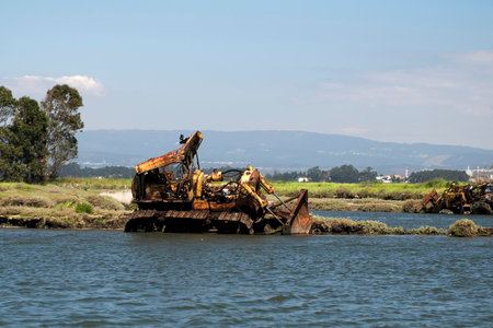An abandoned rusted bulldozer in Aveiro lagoon Ria de Aveiro located on the Atlantic coast of...