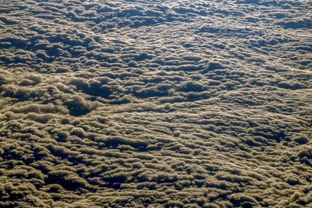Sunrise clouds carpet view from airplane window while flying