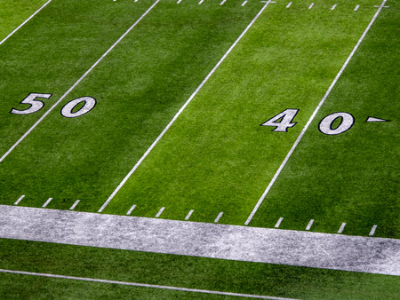 An American football field detail of white chalk drawn lines. 50 and 40 yards line
