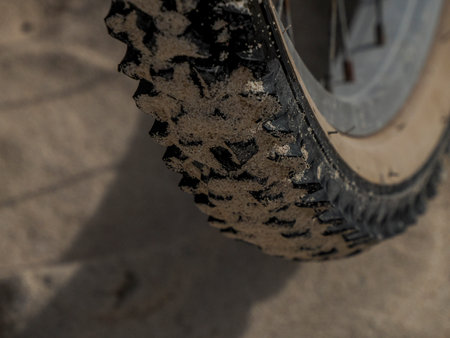 A bicycle tire detail on sand background