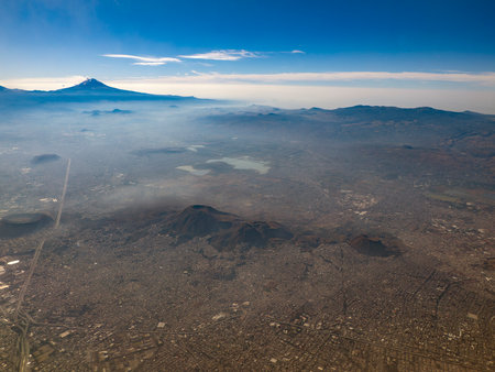 Popocatepetl Xaltepec and other volcanoes and Mexico City aerial view while eruptingの写真素材