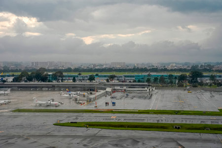 BOGOTA, COLOMBIA - NOVEMBER 3 2025 - The bogota airport aerial view from airplane window landing and taking off strip under the rainの写真素材