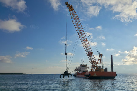 Dredge with crane dredging the sea bottom near the shore