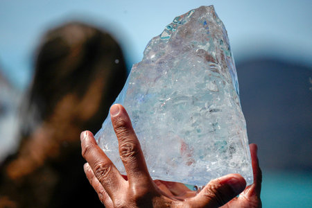 Hand holding piece of ice fallen from the Spegazzini glacier los glaciares park Patagonia Argentina