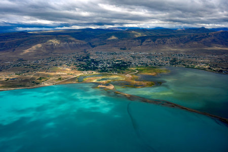 el calafate town and turquoise lake view from aerial from airplane window panorama