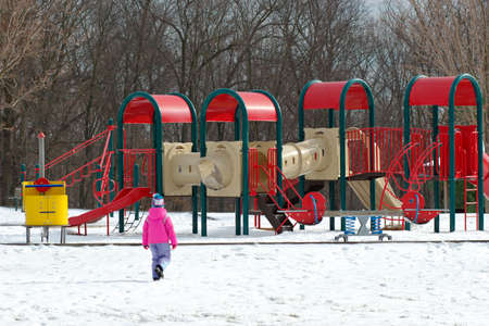 Girl and playground at winterの写真素材