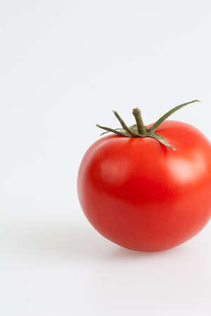 Fresh beuatiful red and delicious tomato on a white backgroundの写真素材