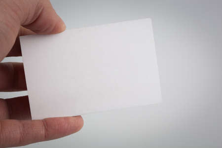 Men's hand holding a white business card