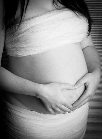 Pregnant woman with hands over her stomachの写真素材