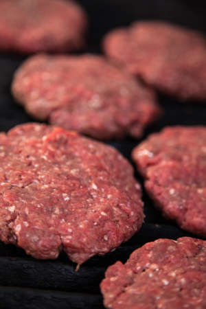 Raw fresh hamburgers on the BBQ grillの写真素材