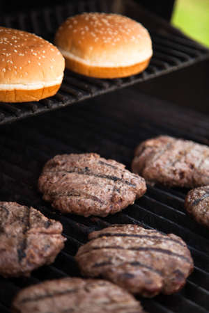 Hamburgers cooking on the BBQ grillの写真素材