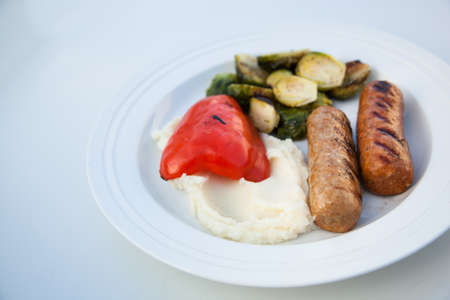 BBQ grilled sausages with mash potatoes and vegetablesの写真素材