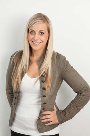 Young blond woman smiling against a white backgroundの写真素材