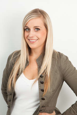 Young blond woman smiling against a white backgroundの写真素材