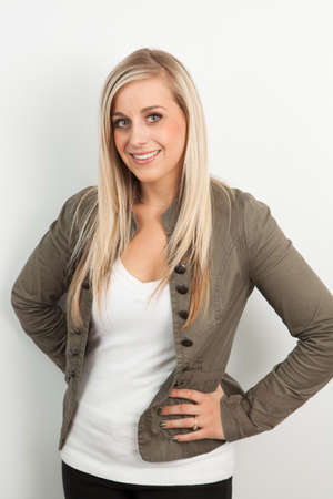 Young blond woman smiling against a white backgroundの写真素材