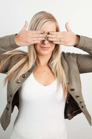 Young blond woman smiling against a white backgroundの写真素材