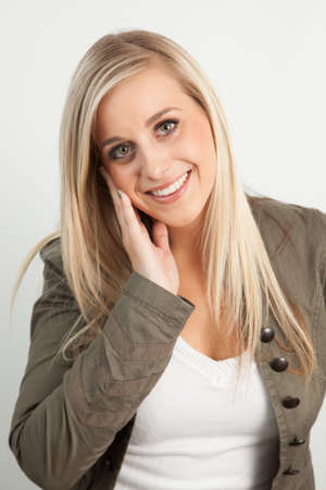 Young blond woman smiling against a white backgroundの写真素材