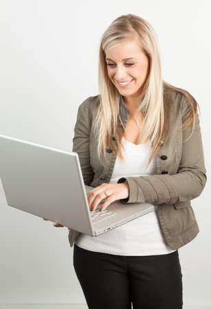 Young blond woman smiling against a white backgroundの写真素材