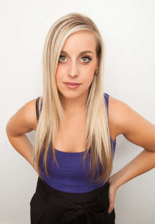 Young blond woman smiling against a white backgroundの写真素材