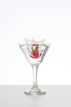 Transparent cocktail with strawberry splashの写真素材