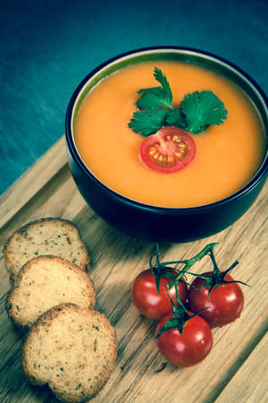 Tomato soup on a wooden plankの写真素材