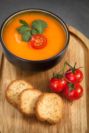 Tomato soup on a wooden plankの写真素材