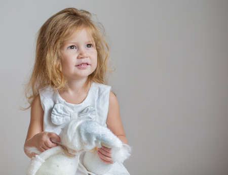 Redhair girl with snowman and angel on light gray background