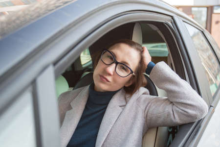 Fashion business woman in glasses driving car